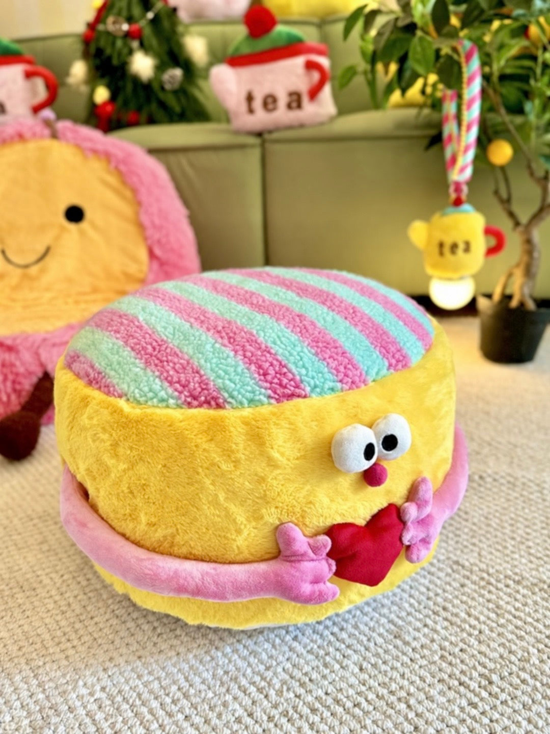 Yellow round pouf ottoman with pink striped top and heart detail